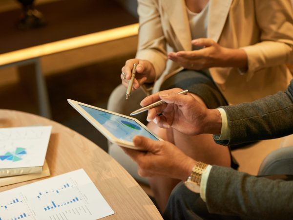 Hands of businessman showing diagram on tablet computer to his coworker