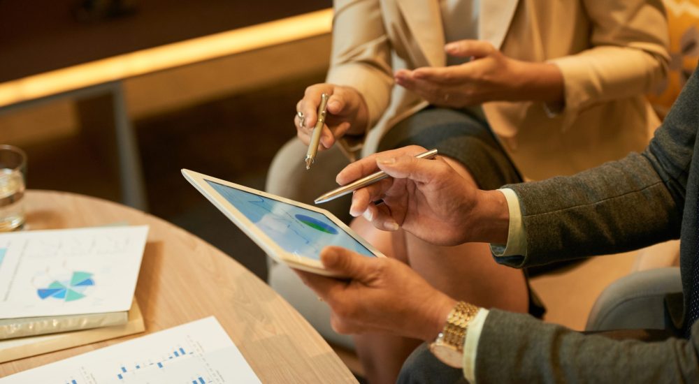 Hands of businessman showing diagram on tablet computer to his coworker